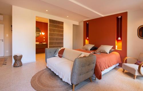 een slaapkamer met een bed en een bank bij Beija Flor in Agay - Saint Raphael