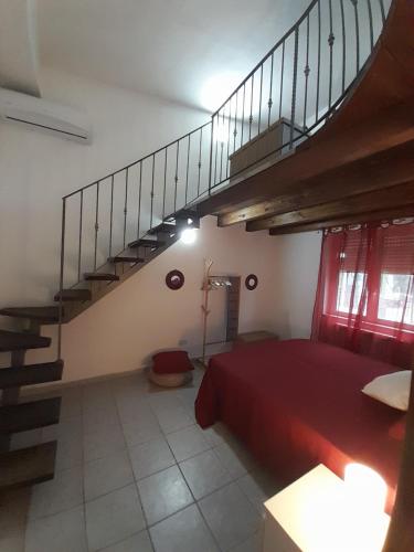 a bedroom with a red bed and a staircase at Casa vacanze Villa Liù in Sciacca