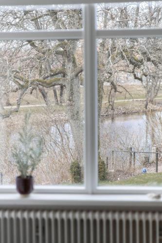 a window with a view of a pond seen through it at Hotell Villa Rönne in Ängelholm