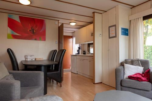 a living room with a table and chairs and a kitchen at Huisje Mooijweer in Putten