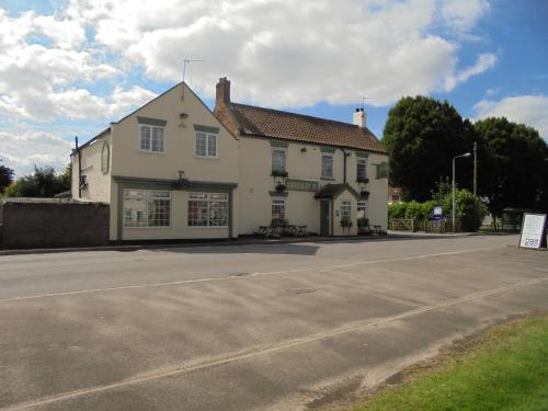 a large white building on the side of a street at The River Don Tavern and Lodge in Crowle