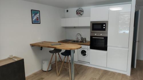 a small kitchen with a wooden table and a counter at Studio avec balcon et vue sur le Sancy in Le Mont-Dore