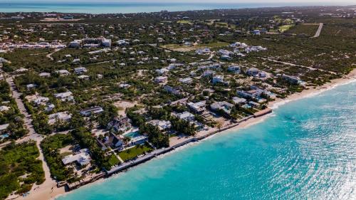 an aerial view of a beach with houses and the ocean at The Atrium Resort in Grace Bay