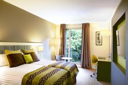 Ένα ή περισσότερα κρεβάτια σε δωμάτιο στο Best Western Plus Paris Meudon Ermitage