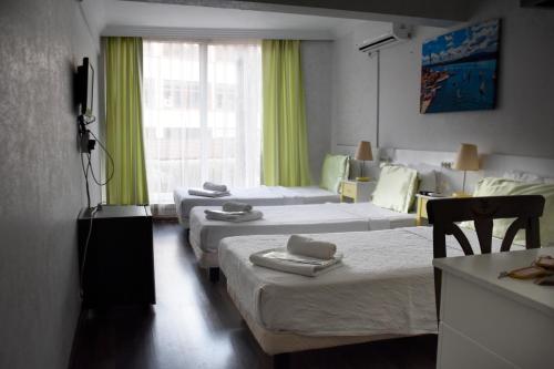 a hotel room with four beds and a window at Yalçın Otel in Antalya