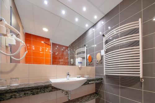 a bathroom with a sink and a mirror at Balneo Hotel Zsori Thermal & Wellness in Mezőkövesd