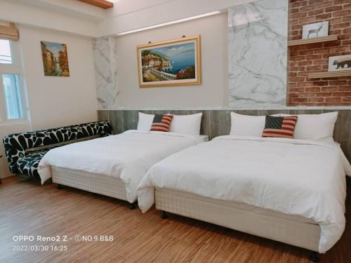 a bedroom with two beds and a couch at 站前9號民宿 in Jian
