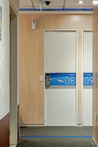 two doors in a room with a sign on it at FAST SLEEP Guarulhos by Slaviero Hotéis in Guarulhos