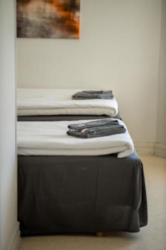 a pile of clothes sitting on top of a bed at Hotell Villa Rönne in Ängelholm