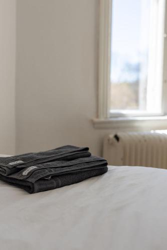 a stack of towels sitting on top of a bed at Hotell Villa Rönne in Ängelholm