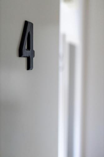 a number four hanging on a white door at Hotell Villa Rönne in Ängelholm