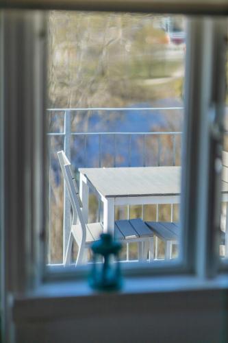 a table and a chair in a window at Hotell Villa Rönne in Ängelholm