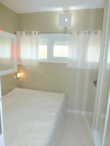 une petite chambre avec un lit et une fenêtre dans l'établissement Appartement Village Naturiste Apollon, au Cap d'Agde