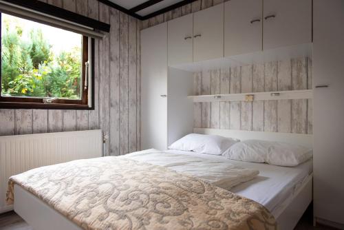 a bedroom with a large white bed with a window at Huisje Weltevree (nummer 95) in Putten