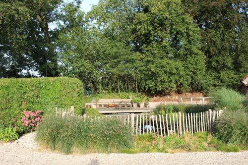 a garden with a white picket fence and a bench at Huize Koempoelan in Naarden