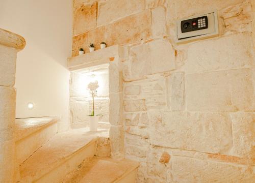 une chambre avec un mur en pierre et une horloge sur le mur dans l'établissement LA PIVOINE, à Vauvert
