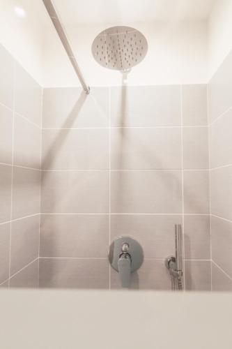 a white tiled shower with a shower head at Residenza I Melograni - Suite in Domaso