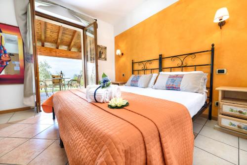 - une chambre avec un lit et une couverture orange dans l'établissement Agriturismo Costadoro, à Bardolino