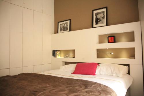 Un dormitorio con una cama con una almohada roja. en Sèvres-Raspail Paris 6 apartment, en París