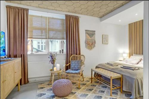 a bedroom with a bed and a chair and a window at Boheme Retreat in Aalborg