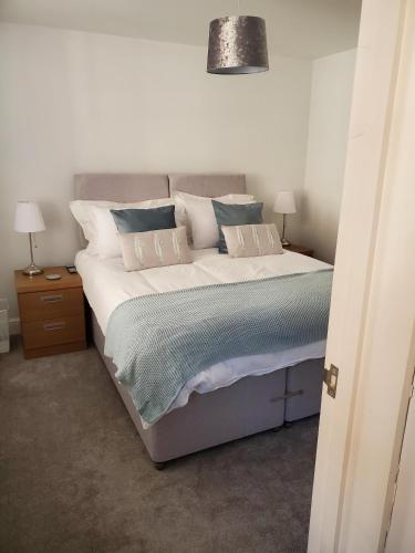 um quarto com uma cama grande com almofadas brancas e azuis em Ipswich Town Centre - Apartment 1 em Ipswich