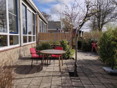 a table and chairs in front of a house at LOGEMENT DE SCHOOL Middelburg in Middelburg