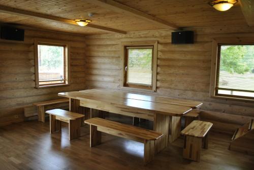 a dining room with a wooden table and benches at Vilks un Briedis Holiday Home & Wellness Area in Smiltene