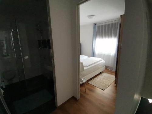 a bathroom with a shower and a bedroom with a bed at Ferienwohnung mit Aussicht auf die Burg in Wertheim