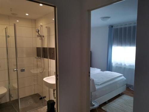 a bathroom with a shower and a bed and a sink at Ferienwohnung mit Aussicht auf die Burg in Wertheim