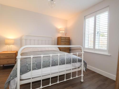 Un dormitorio con una cama blanca y una ventana. en Ty Owen, en Newport
