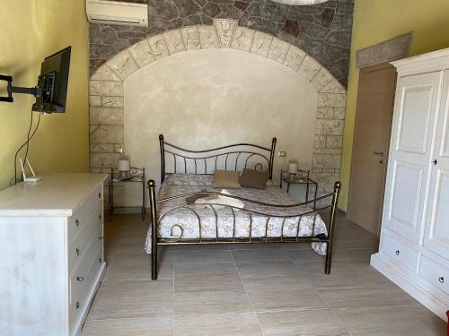 1 dormitorio con cama y pared de piedra en Agriturismo Abbalughente en Sindia