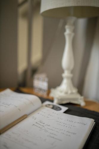 an open book sitting on a table next to a lamp at Hotell Villa Rönne in Ängelholm