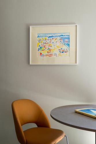 a table with a chair and a picture on the wall at Allegroitalia La Spezia 5 Terre in La Spezia