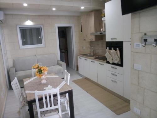 a kitchen and living room with a table and a couch at Casa Vacanza Al Duomo in Barletta