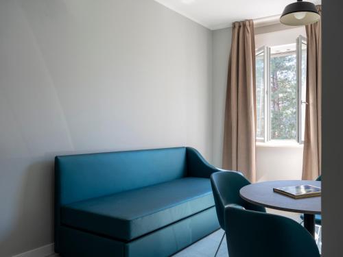 a living room with a blue couch and a table at Allegroitalia La Spezia 5 Terre in La Spezia