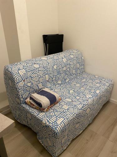eine blaue und weiße Couch mit einer Decke drauf in der Unterkunft Mini studio 9m2 - 027 in Rouen