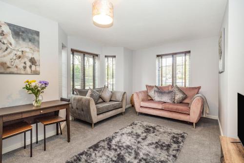 a living room with two chairs and a table at Mayfair in Wigan