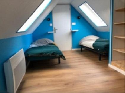 - une chambre avec 2 lits dans une chambre aux murs bleus dans l'établissement Gîte de Vercourt, à Vercourt