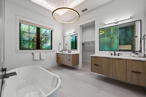 a bathroom with a tub and two sinks and a mirror at The Ringling Estate in Sarasota