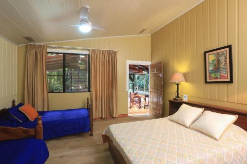 um quarto com uma cama e um sofá azul em Horquetas River Lodge em Sarapiquí