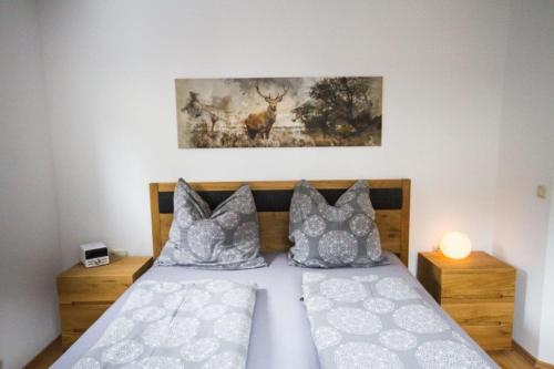 a bedroom with a bed with pillows and a painting at Apartment Mayerhofer in Fulpmes