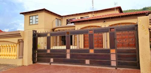 una casa con una puerta de garaje de madera delante de ella en Asda guesthouse, en Mogwase