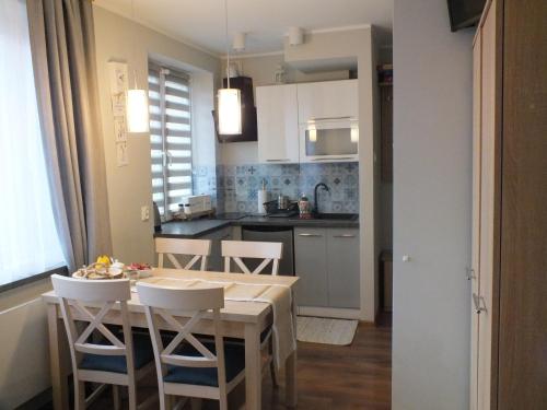 a kitchen with a table and chairs in a room at Słoneczne studio in Szczawnica