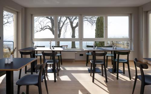 a restaurant with tables and chairs and windows at Hofgut Wißberg - Das Weinberghotel in Sankt Johann
