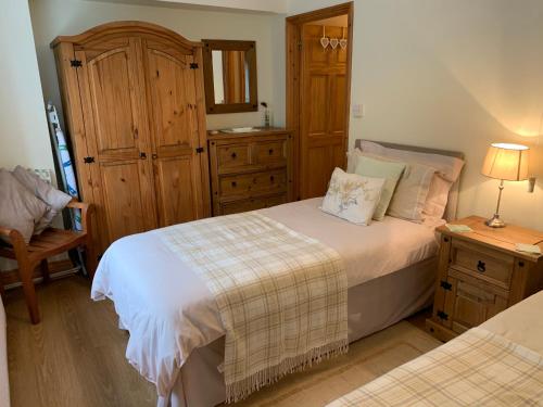 a small bedroom with two beds and a dresser at Parc Farm B&B in Llanarth