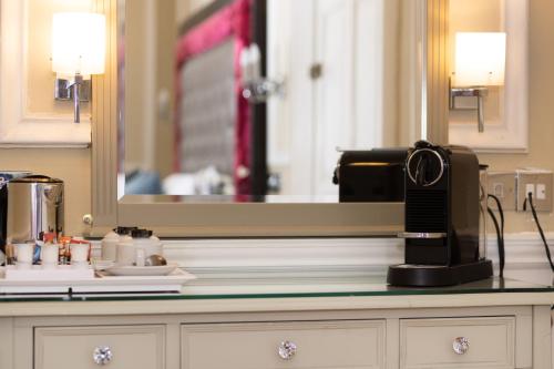 a kitchen counter with a coffee maker and a mirror at The Haymarket Hotel in Edinburgh