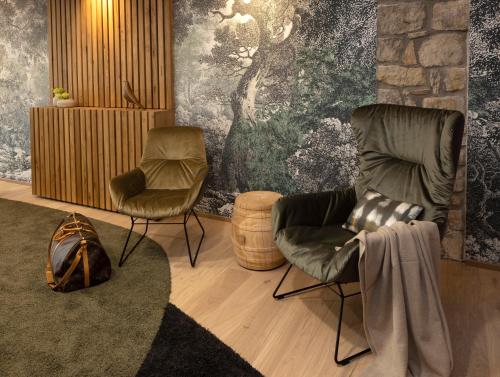 a living room with two chairs and a rug at Hofgut Wißberg - Das Weinberghotel in Sankt Johann
