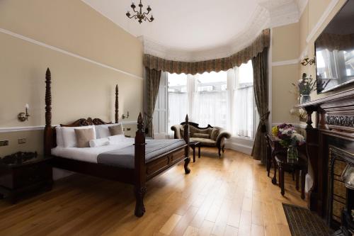 a bedroom with a bed and a chair and a window at The Haymarket Hotel in Edinburgh