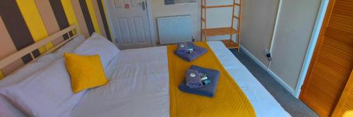 a bedroom with a white bed with two controllers on it at Sportsmans Valley Hotel in Liskeard