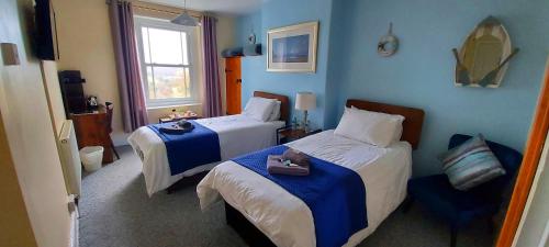 a hotel room with two beds and a window at Sportsmans Valley Hotel in Liskeard